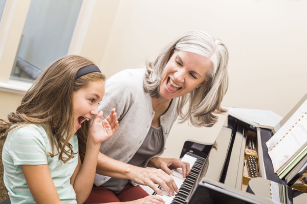 Caucasian grandmother and granddaughter playing piano