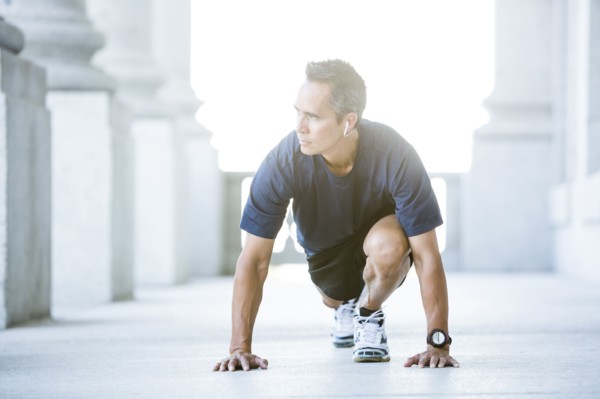 Mixed race man stretching outside courthouse