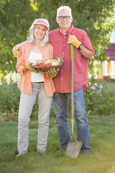 Caucasian couple gardening in backyard
