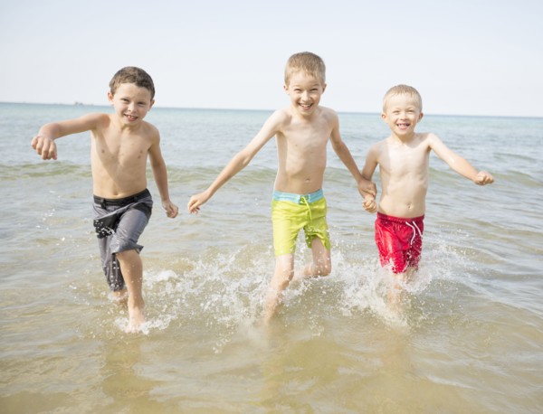 Caucasian boys playing in waves on beach
