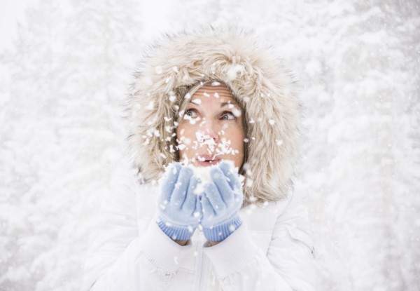 Caucasian woman playing in snow