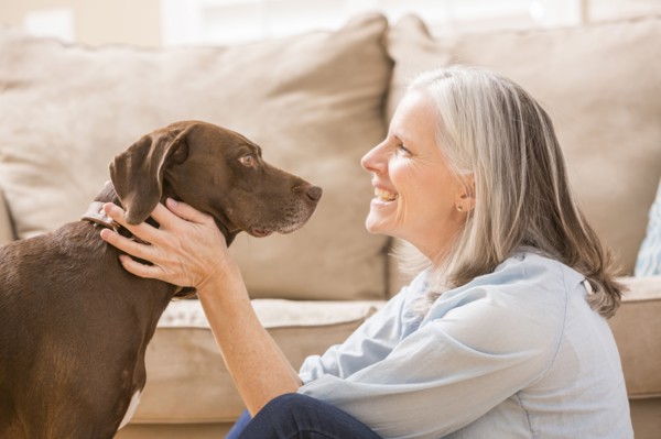 Caucasian woman hugging dog in living room