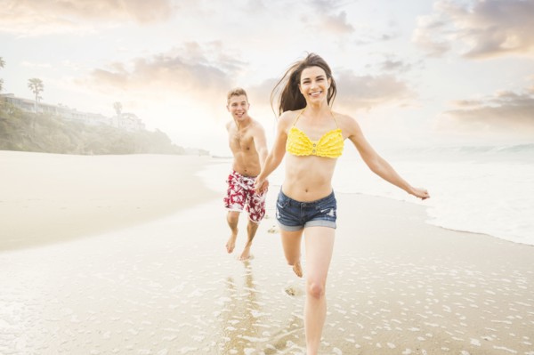 Caucasian couple running on beach