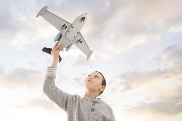 Caucasian boy flying toy airplane