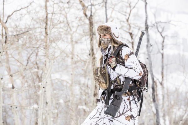 Caucasian woman hunting in forest wearing bandana
