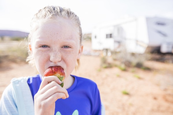 Caucasian girl biting strawberry