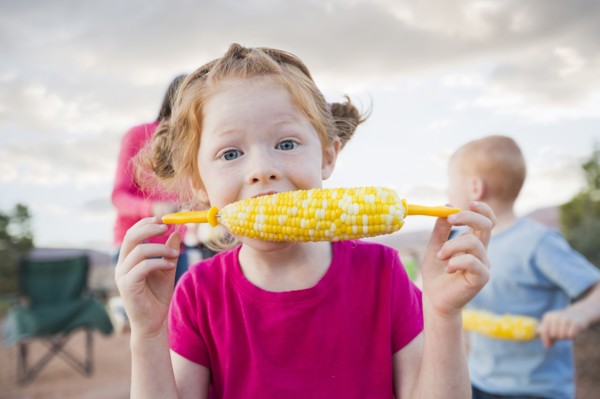 Caucasian girl eating corn on the cob