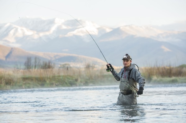 Caucasian man fly fishing in river