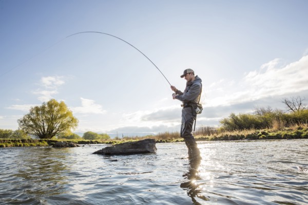 Caucasian man fly fishing in river