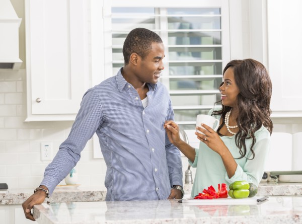 Black couple smiling in kitchen