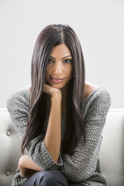 Portrait of serious Indian woman sitting on sofa