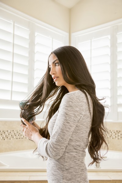 Mixed Race woman brushing hair in bathroom