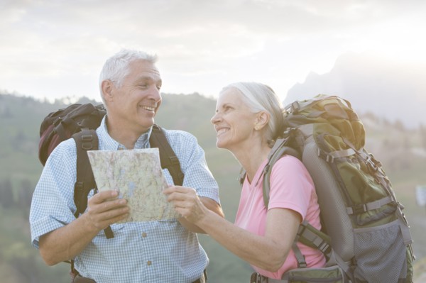 Caucasian couple hiking with map on mountain