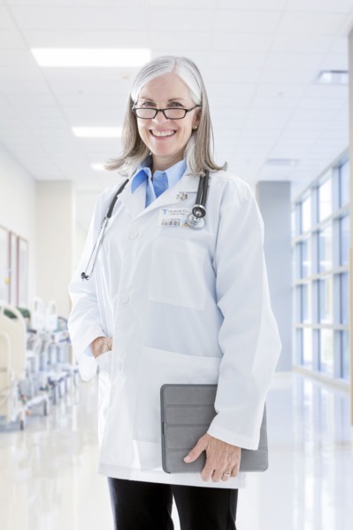 Portrait of smiling Caucasian doctor holding digital tablet