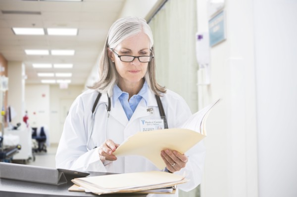 Caucasian doctor reading files in hospital