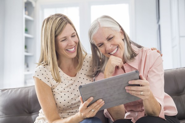 Smiling Caucasian women using digital tablet