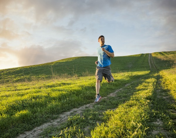 Hispanic man running on hill