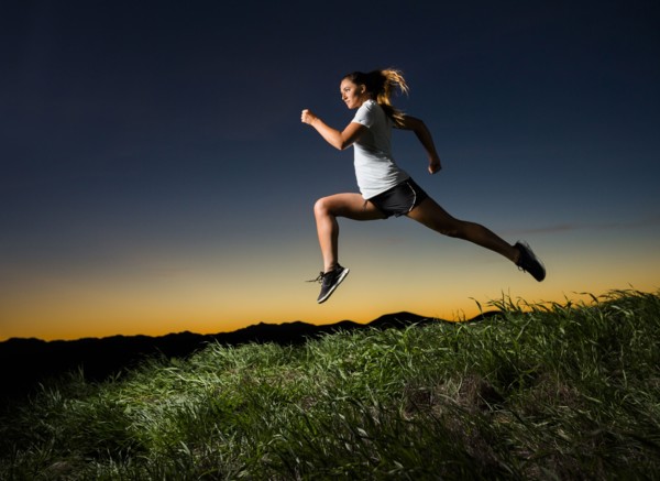 Caucasian woman running at sunset