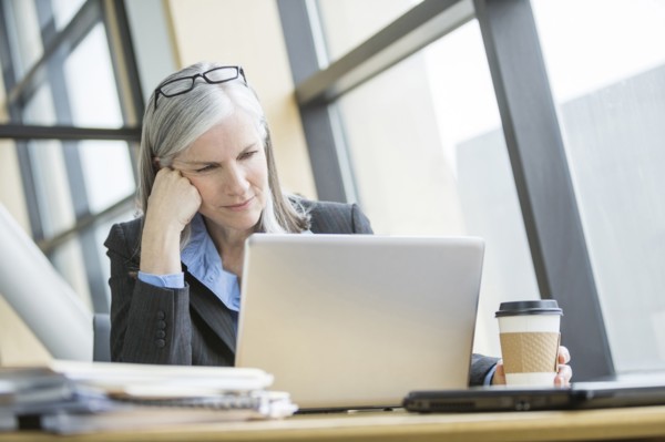 Frustrated Caucasian businesswoman using laptop