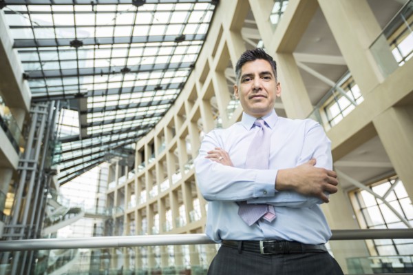 Serious Mixed Race businessman posing in lobby