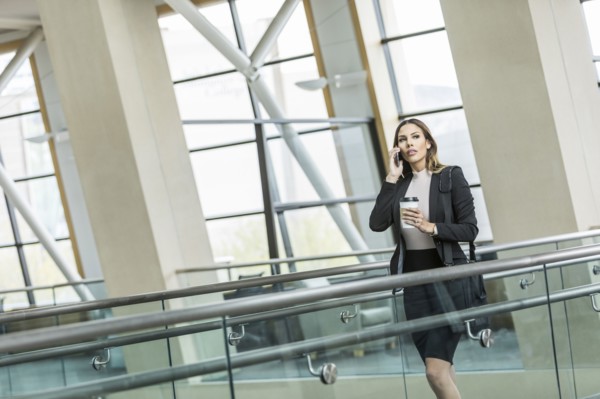 Mixed Race businesswoman talking on cell phone in lobby