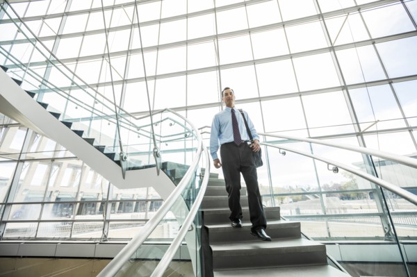 Mixed Race businessman descending staircase