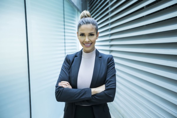 Portrait of smiling Mixed Race businesswoman in corridor