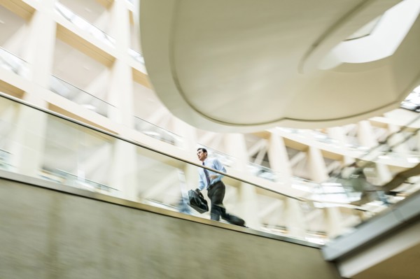 Mixed Race businessman running late in lobby
