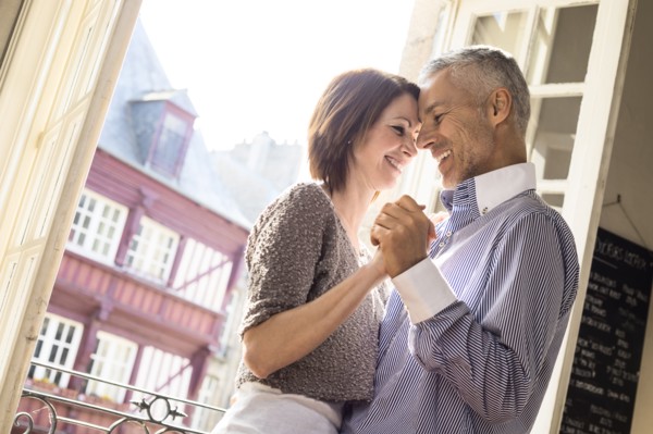 Caucasian couple dancing near doorway