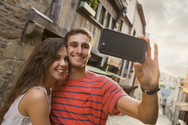 Caucasian couple posing for cell phone selfie