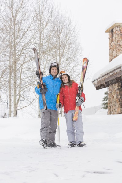 Portrait of smiling Caucasian couple carrying skis