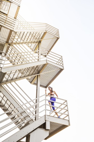 Caucasian woman running on urban staircase