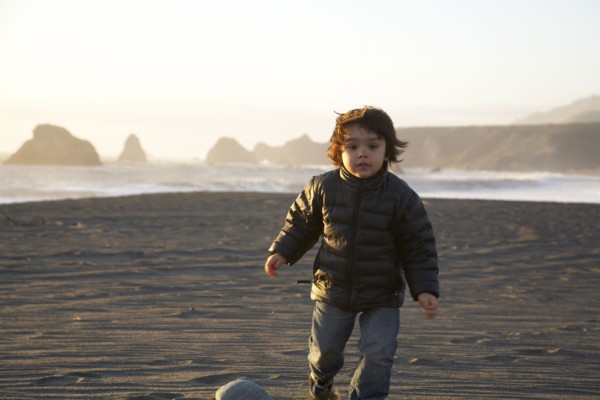 Mixed race boy running on beach
