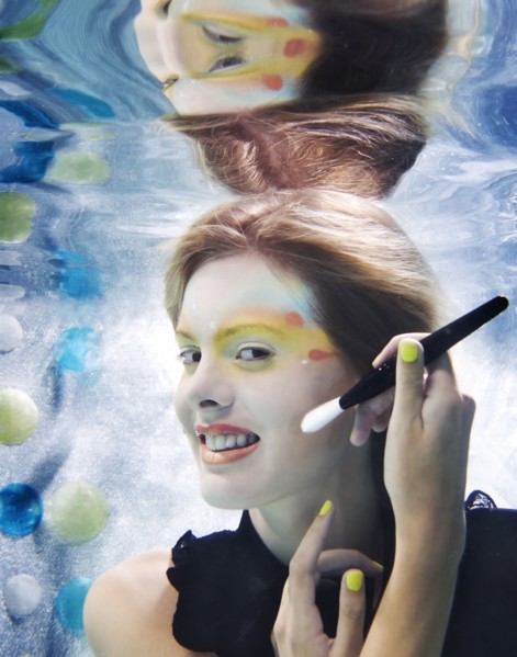 Caucasian putting makeup on under water