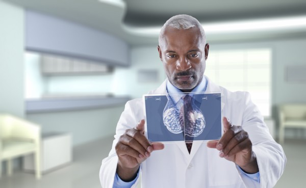 Black doctor using digital display in doctor's office
