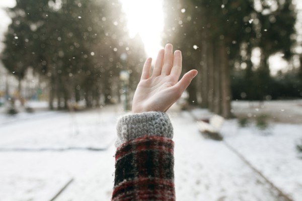 Hand of Caucasian woman catching falling snow