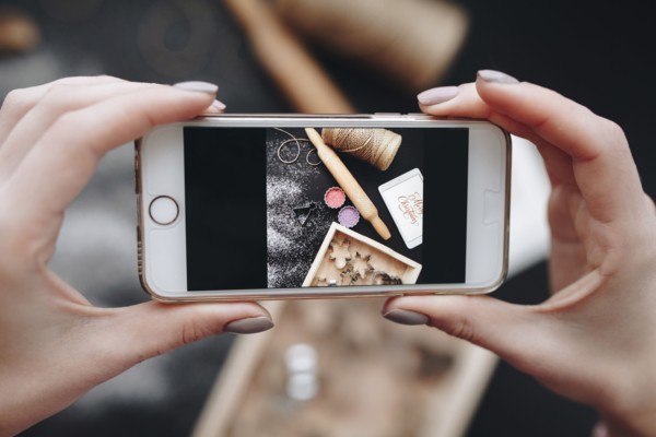 Hands of Caucasian woman photographing baking supplies