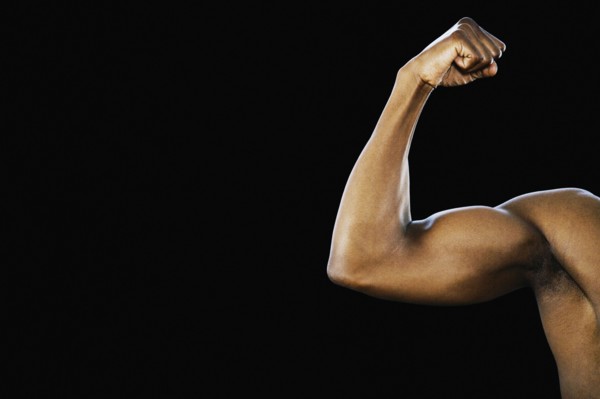 Studio shot of African man flexing biceps