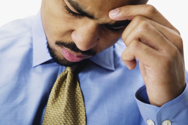 Close up of African businessman with head in hand