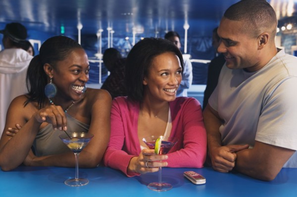 Three African friends laughing at bar
