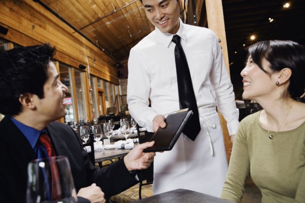 Asian couple paying restaurant bill