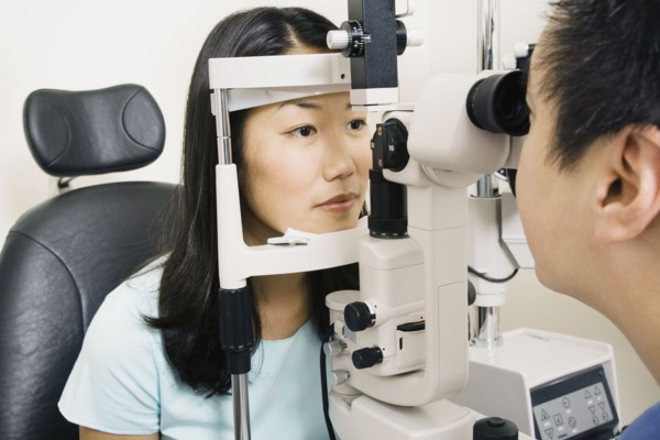 Asian male optometrist examining patient