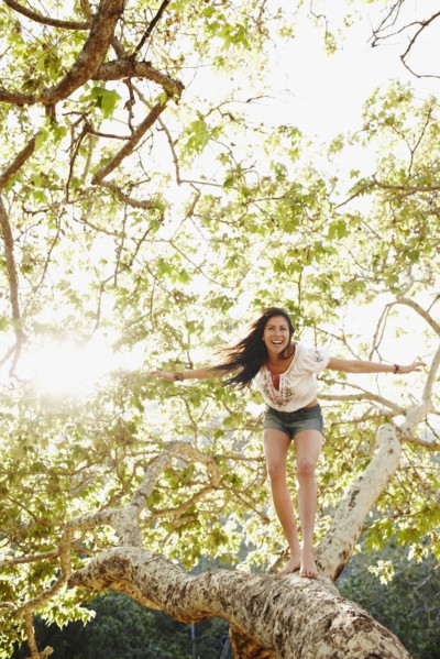 Hispanic woman standing on tree branch