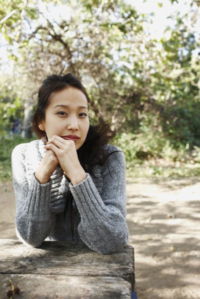 Asian woman sitting at picnic bench