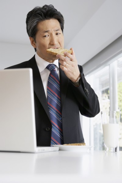 Asian businessman eating toast