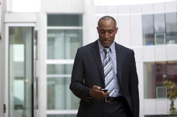 Mixed race man looking at cell phone