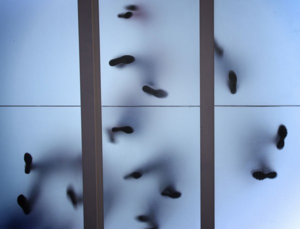 Silhouette of feet standing on glass ceiling