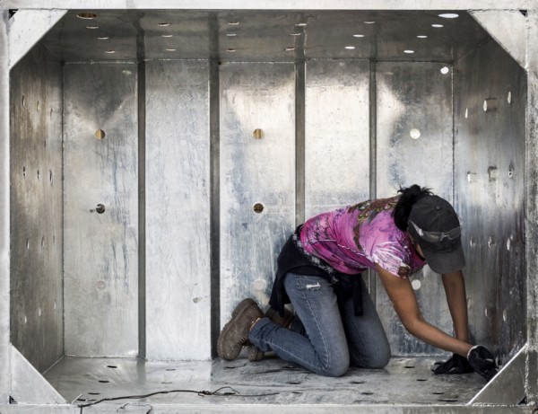 Worker examining metal walls