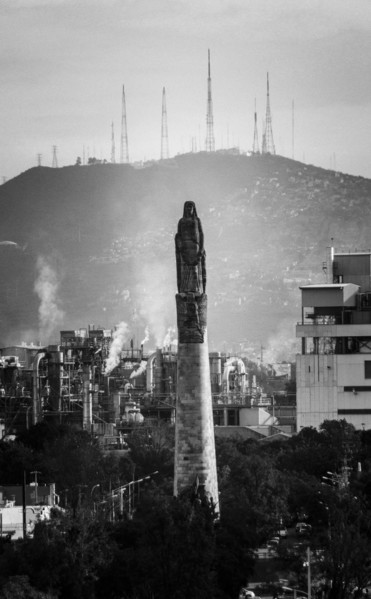 Statue on pillar in cityscape