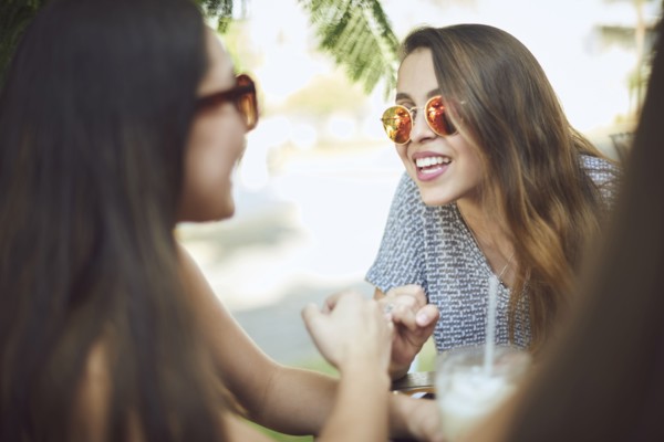 Smiling Hispanic women wearing sunglasses